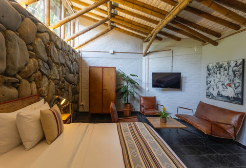 Bedroom 3 - 🌿 Welcome to your rustic retreat, where natural light dances through vaulted ceilings adorned with cozy wooden beams, creating a haven of tranquility. Sink into the luxurious leather seating, surrounded by warm stone walls and lush greenery, a