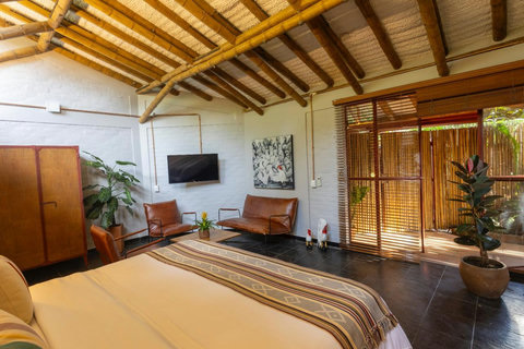 Bedroom 1 - Unwind in rustic elegance with bamboo accents and warm natural light. Immerse yourself in relaxation with cozy seating and lush greenery, creating the perfect escape from the everyday hustle.