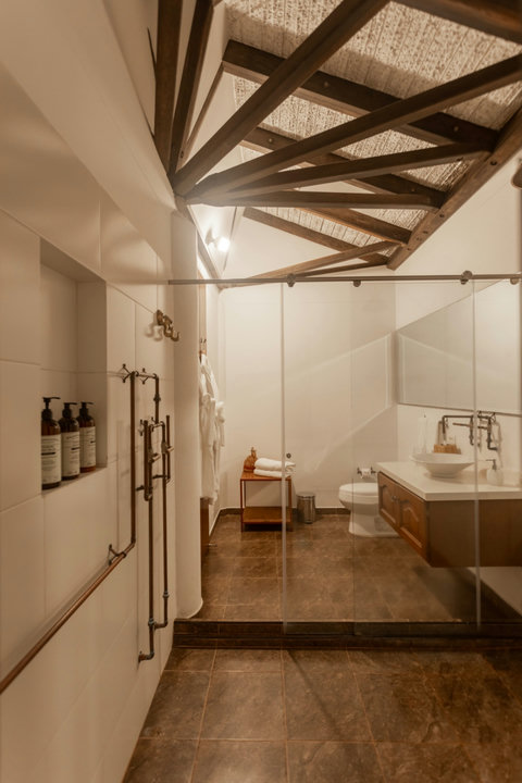 Bathroom - Step into serenity with this stunning bathroom oasis. Bask in the warm, ambient lighting as natural wood accents and luxurious amenities invite you to unwind and rejuvenate. Your ultimate escape awaits.