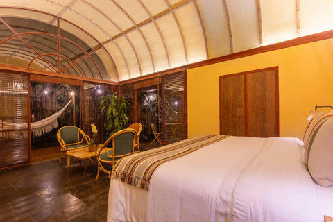 Bedroom 2 - Bedroom 2 - Escape to tranquility in this cozy oasis, where natural light pours through the expansive windows, highlighting the elegant wooden beams and luxurious amenities. Unwind on the private patio surrounded by lush greenery, and let the