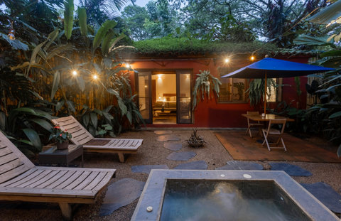 Patio - Step into paradise where lush greenery meets warm ambiance. Relax under twinkling lights, soak in nature's beauty, and unwind in this charming hideaway filled with cozy comforts and a serene vibe. Perfect for your next retreat.