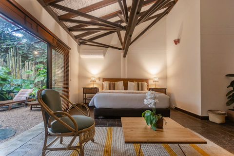 Bedroom 2 - Escape to tranquility in this cozy oasis, where natural light pours through the expansive windows, highlighting the elegant wooden beams and luxurious amenities. Unwind on the private patio surrounded by lush greenery, and let the serene ambia