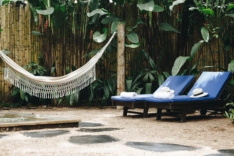Patio Common Area - Unwind in paradise with our serene outdoor lounge, where lush greenery meets luxurious comfort. Bask in the golden glow of sunset from your hammock or relax on cozy sun loungers. Perfect for escaping into a tranquil oasis!