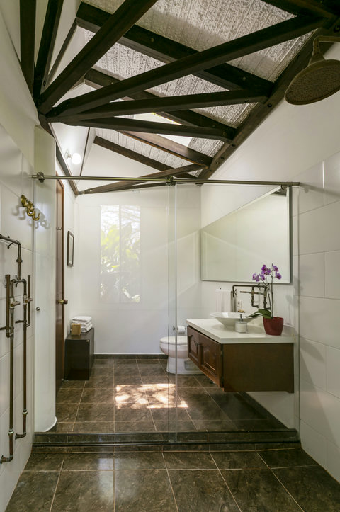 Bathroom - Step into serenity in this beautifully lit bathroom oasis, where rustic charm meets modern elegance. Enjoy your morning routine beneath an enchanting skylight that bathes the space in natural light, surrounded by lush greenery just outside. Tre