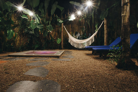 Patio area - Escape to your own tropical oasis where relaxation meets luxury. Bask under the serene canopy of lush greenery, unwind in the cozy hammock, or soak in the warm glow of the evening fairy lights. Your perfect getaway starts here!