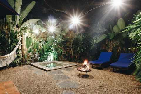 Patio -  Unwind in tropical bliss with the warmth of a crackling firepit and the gentle embrace of lush greenery. Bask in golden sunlight on our comfy loungers, where serenity meets style. 🌿🔥 #TropicalRetreat #CozyEscape