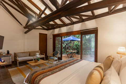 Bedroom 3  - Step into serenity with this charming retreat, where natural light dances through wooden beams and a private patio awaits just outside. Unwind in comfort with cozy seating and a luxurious bed that promises restful nights. This is your haven o
