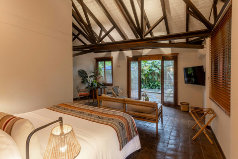 Bedroom 2  - Escape to tranquility in this tropical oasis, where rustic beams and natural light create a serene retreat. Enjoy the lush garden views from your cozy bed, and unwind in style with all the comforts you need for a rejuvenating stay.