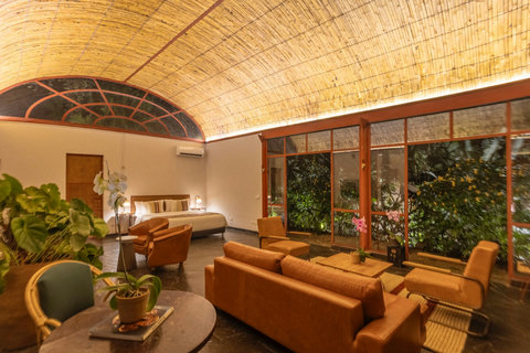 bedroom 1 - Indulge in the perfect blend of luxury and comfort in this serene retreat. With its warm ambient lighting dancing across the bamboo-clad ceilings, cozy seating, and lush greenery, this space invites you to unwind and escape. Your tranquil geta