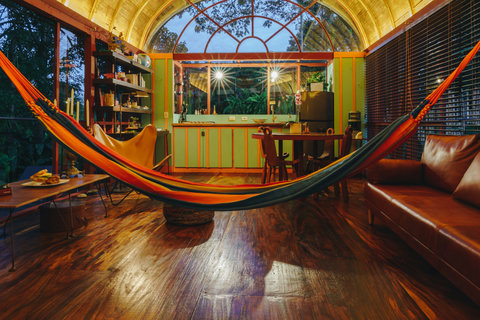 living room 2 - 🌿✨ Embrace the perfect blend of nature and comfort in our eco-friendly retreat, where the warm, ambient glow enhances the tropical charm. Hang loose in the colorful hammock, relish meals prepared with love in the fully equipped kitchen, an