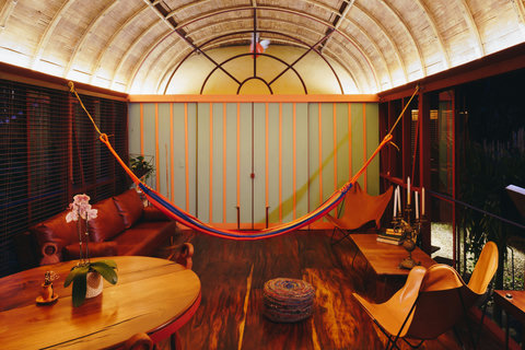 living room 2 - Bask in the golden glow of this enchanting oasis, where rustic charm meets modern comfort. Unwind in the cozy hammock, savor meals with a jungle backdrop, and let the serene vibes of this woodland retreat captivate your soul.
