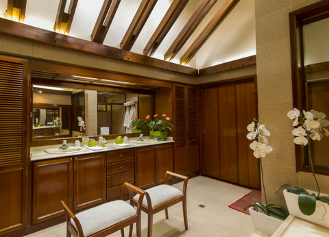 Bathroom - Step into luxury where warm wood accents meet soft ambient lighting. Unwind in this serene retreat, complete with elegant double sinks and blooming orchids enhancing your pampering experience.