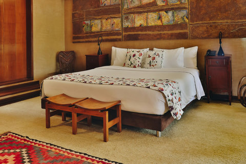 Bedroom 2 - Step into tranquility where rustic charm meets modern elegance. This spacious room, bathed in warm lighting and adorned with artistic accents, offers a serene escape. Unwind in the cozy reading nook, relax in the luxurious king-sized bed, and