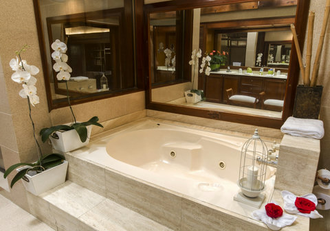 Bathroom 1 - Step into luxury and total relaxation with our serene, softly-lit spa bathroom, featuring an indulgent jacuzzi tub. Unwind amidst orchids and candlelight for a rejuvenating experience.