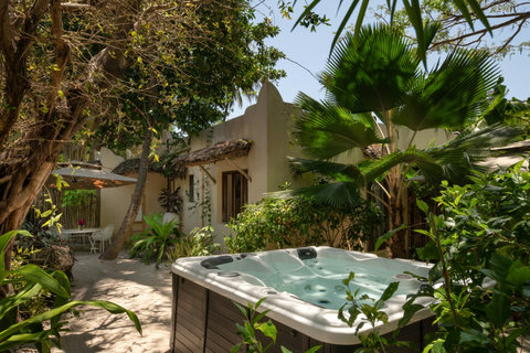 A few steps deeper, warm water waits between palms, where the afternoon slows and privacy feels beautifully complete.