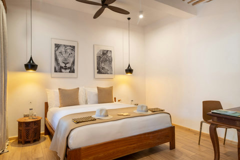 By late afternoon, crisp linens and warm wood invite a slower pace, with air moving gently around the room.