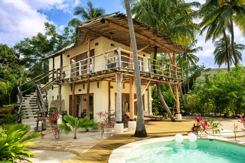 From the poolside deck, the day feels wide and weightless, with water glimmering beneath palms and warmth settling into skin.