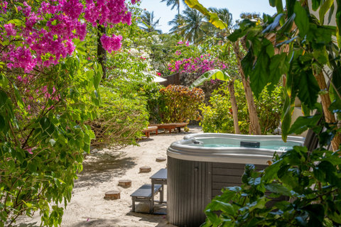 A few steps later, the garden opens around warm water, bright blooms, and air that feels washed clean.