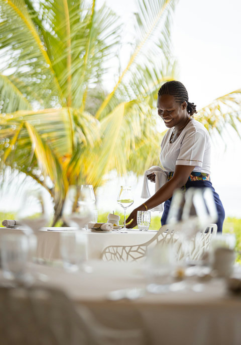 Lunch drifts into afternoon, with linen, glassware, and palm-framed light setting a mood that feels quietly cared for.