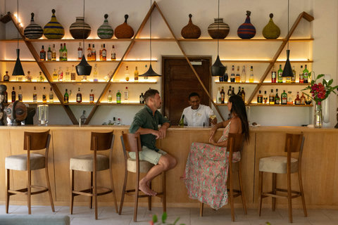 As evening gathers, the bar glows softly, conversation lingers, and the day loosens into something warmer.