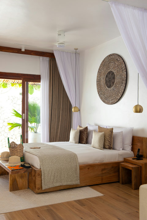 Morning light skims crisp linen, carved wall art, and warm wood, made for lingering longer.