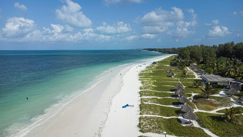 From above, the shoreline feels endless, white sand tracing the water while the afternoon settles into something weightless.