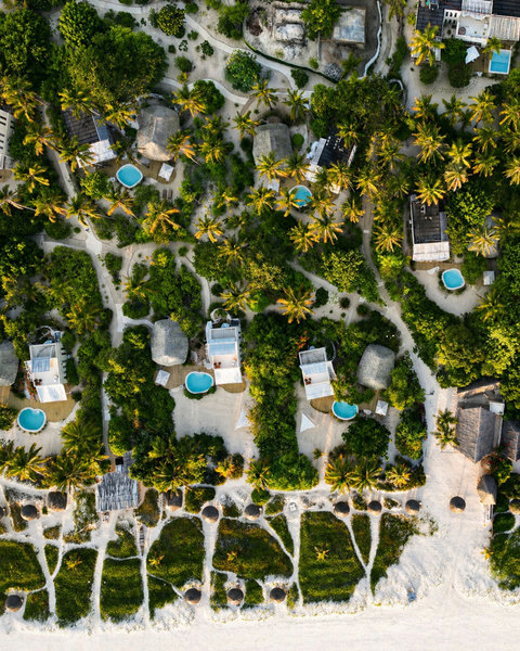 From above, the whole retreat softens into dusk, palms glowing, paths winding home, and the day exhaling beautifully.