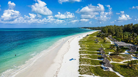 Then the coastline opens wide, white sand and clear water stretching outward in a kind of effortless calm.