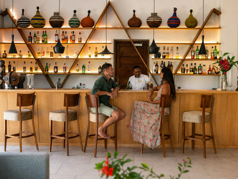 At the bar, warm light, local spirits, and an easy toast to nights that linger.