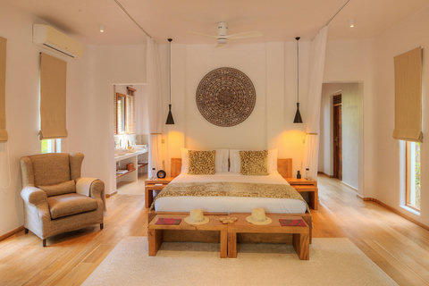 A centered bed, warm wood, and soft lamps, the room feels like a deep exhale.