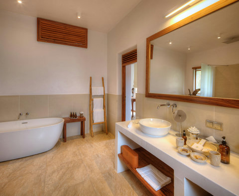 Fresh towels, sunlit mirror, and clean edges, the kind of bathroom that feels quietly curated.