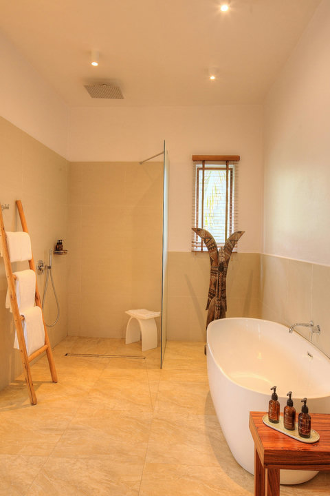 An open shower, warm stone, and evening light, where rinsing off feels like a small reset.