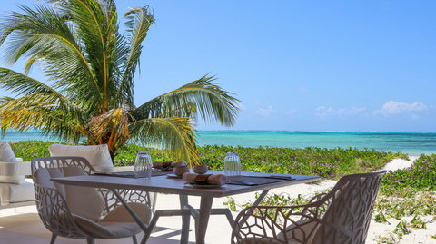 Breakfast lingers on the terrace, palms shifting overhead, sea colors brightening with every easy sip.