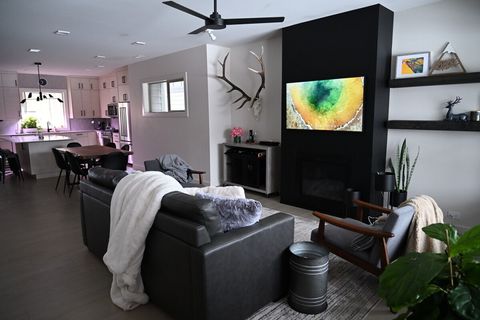 Open concept living room with metal wrapped fire place and bar