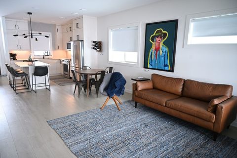 Open concept living area with remote control and voice enabled smart shades