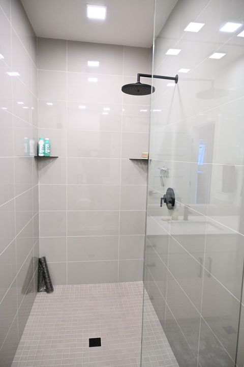 Huge walk in shower with rain shower head and shampoo and soap trays.