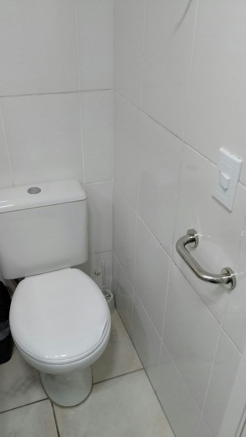 Banheiro social com alças de apoio para idosos.