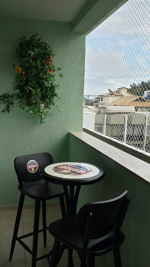 Varanda da sala de estar, com mesa bistrô e cadeira.
