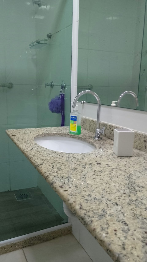 Lavatório no banheiro social com torneira alta.