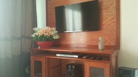 Sala de estar com: smart tv 50", aparelho de som 3 e m 1, sofá e cortinas.