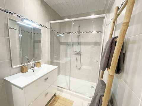 Bathroom: View to shower, sink, mirror and bambu towel rack 