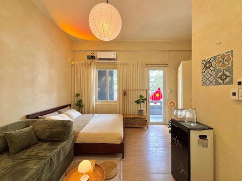 Spacious and airy with natural light streaming through a large window and balcony door. The creamy walls, soft curtains, and warm lighting create a cozy feel, while the private balcony invites you to step out and enjoy fresh air and city views