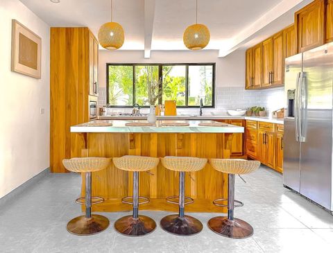 Kitchen: Stylish island bar with modern seating, bask in natural light while you create culinary delights!