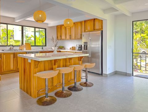 Kitchen: Sunlit space with modern decor, a spacious island, and tropical views inviting culinary adventures!
