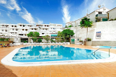 Poolside oasis with crystal-clear water and a sunny sunbathing area.