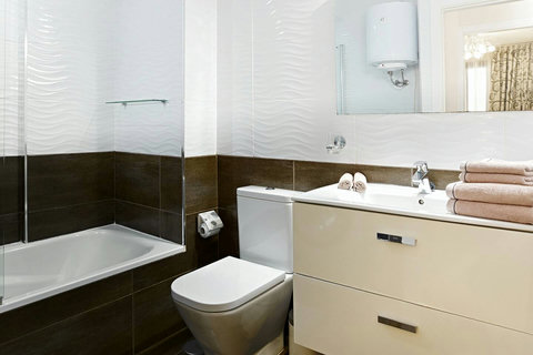 Clean, modern bathroom with full-size bathtub, shower, and washing machine.