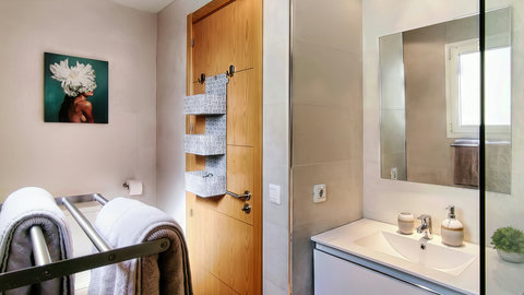 Bright, modern bath with plush towels, sleek vanity, and natural light.