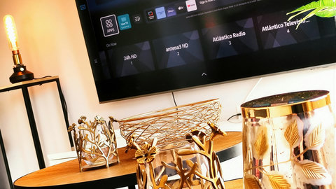 Modern lounge with smart TV, warm lighting, and chic gold accents.