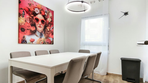 Sunny dining for six with modern ring light and bold wall art