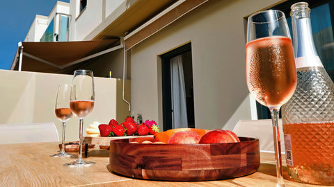 Sunny patio with rosé, fresh fruit, and shaded al fresco dining